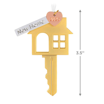 Gold metal key ornament shaped like a house with a pink heart and “New Home” banner charm, for new homeowners.