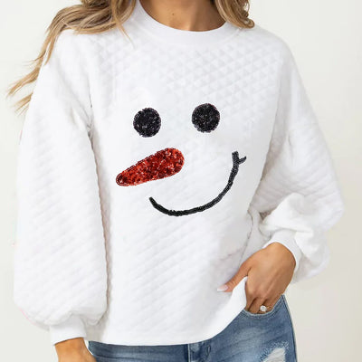 White quilted sweatshirt with smiling snowman face, featuring sequin carrot nose and eyes.