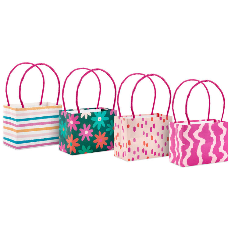 Assorted mini horizontal gift bags with pink stripes, polka dots, squiggles, and multicolor daisies, pink handles, Hallmark

