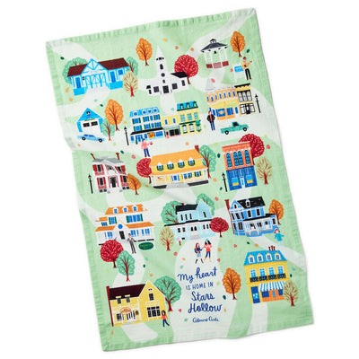 White tea towel printed with a whimsical Stars Hollow map and a central Gilmore Girls quote, includes a loop for hanging.
