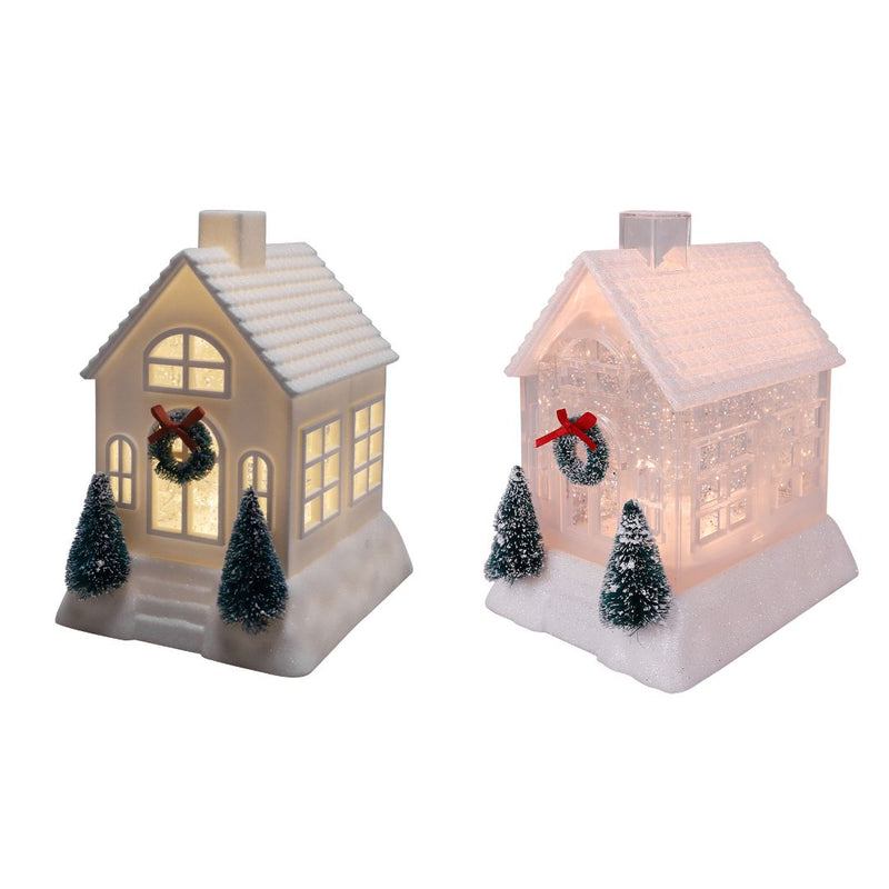 Assorted ivory and pink glittery Christmas houses with bottlebrush trees, wreaths, and warm light.
