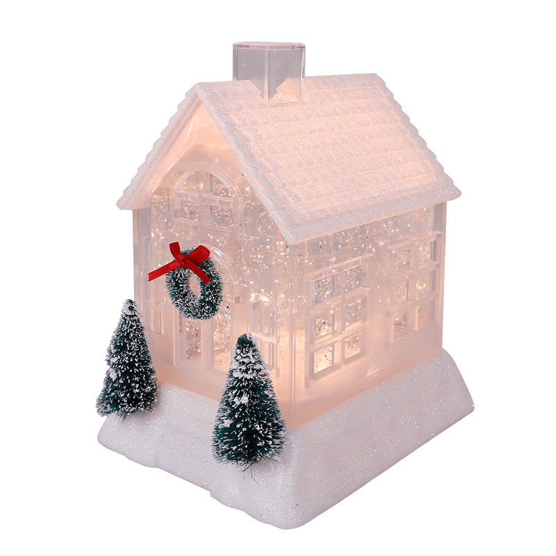 Assorted ivory and pink glittery Christmas houses with bottlebrush trees, wreaths, and warm light.
