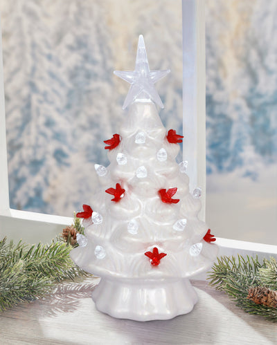 White iridescent ceramic LED Christmas tree with red cardinal accents and soft glowing light.