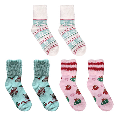 Assorted fuzzy socks in pink, teal, and neutral tones with cocoa mugs and snowflake patterns.