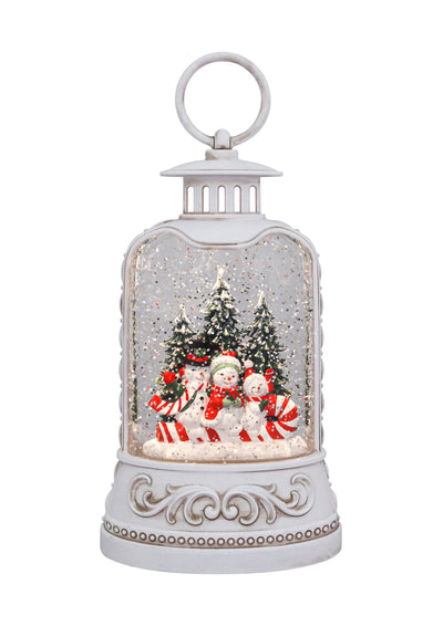 White lantern with snowman family, candy canes, snowy trees, and swirling glitter glow.
