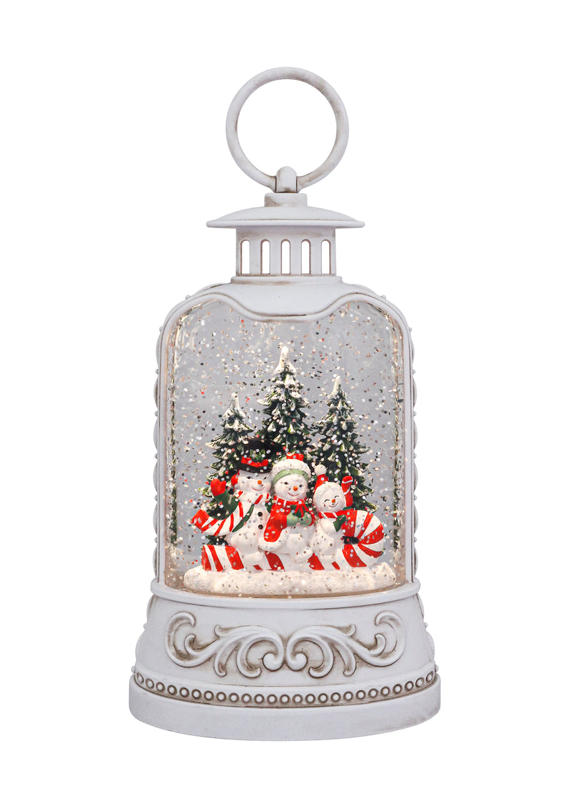 White lantern with snowman family, candy canes, snowy trees, and swirling glitter glow.
