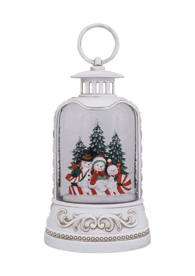 White lantern with snowman family, candy canes, snowy trees, and swirling glitter glow.
