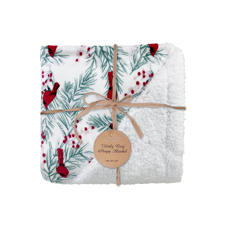 White fleece Sherpa blanket with red cardinals, holly, and pine branches on soft velvety fabric.