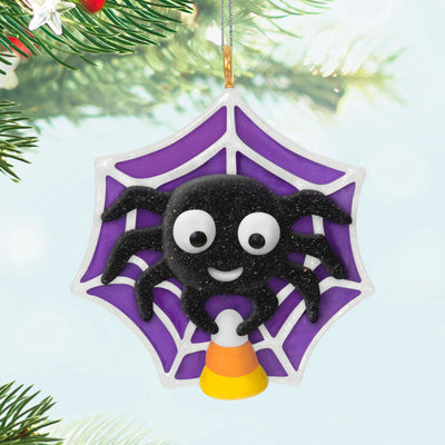 Mini Halloween spider ornament holding candy corn in sparkly web, perfect for tabletop tree display