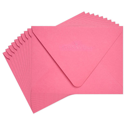 Bright pink envelopes with gold and white halftone dot design inside the flap and pointed edges.
