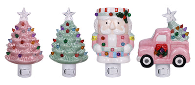 Assorted ceramic night lights with sugarplum designs including pink Christmas trees, Santa, and a festive red truck.