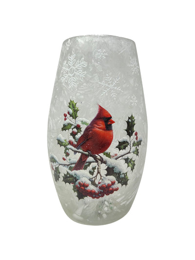 Glowing crackled glass vase with red cardinal perched on snowy winter branches.
