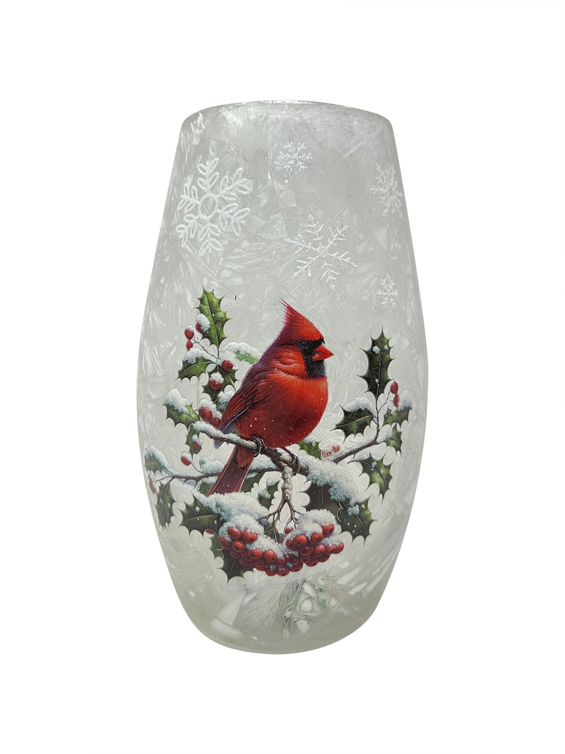 Glowing crackled glass vase with red cardinal perched on snowy winter branches.
