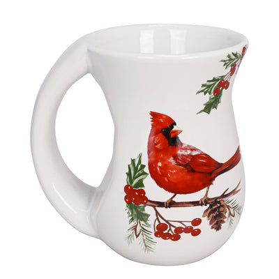 White ceramic mug with red cardinal perched on holly branches, curved body and comfort-grip handle.