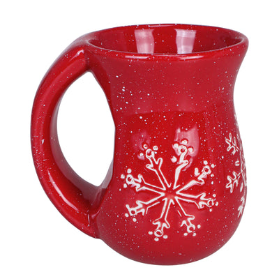 Cranberry red ceramic mug with white snowflake pattern and rounded body with large handle.