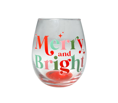 Clear stemless wine glass with red and green “Merry and Bright” lettering and festive holiday accents.
