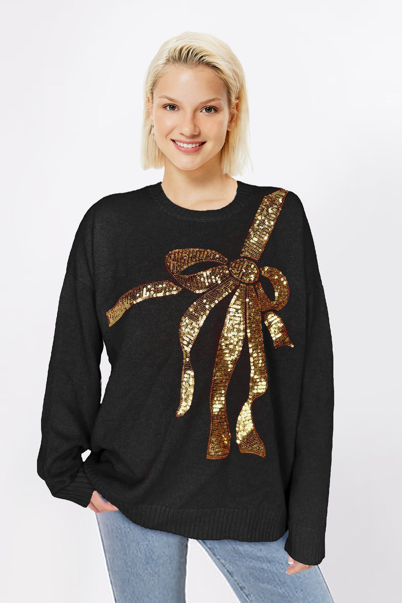 Black sweater with oversized gold sequin bow across the chest, displayed on mannequin.