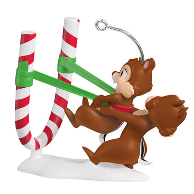 Chip launches Dale from a candy cane catapult in this playful Hallmark Keepsake Disney Christmas ornament with snowy base.