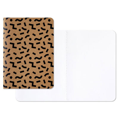 Stationery set with black and kraft notebooks and a memo pad featuring “Noted” and “Hidden Agenda” covers with geometric designs.
