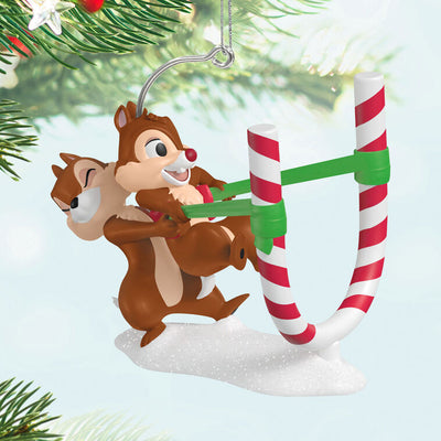 Chip launches Dale from a candy cane catapult in this playful Hallmark Keepsake Disney Christmas ornament with snowy base.