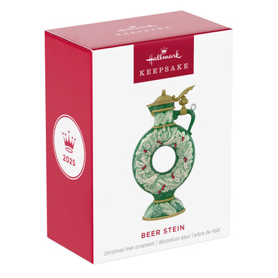 Green beer stein ornament with vintage wreath design, holly, and pinecones; features a gold lid and elegant holiday detailing.