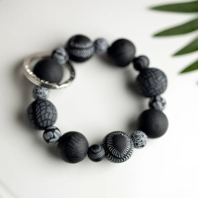 Midnight Palm Keychain with handcrafted black clay beads, elastic cord, and silver key ring featuring JILZARAH logo.
