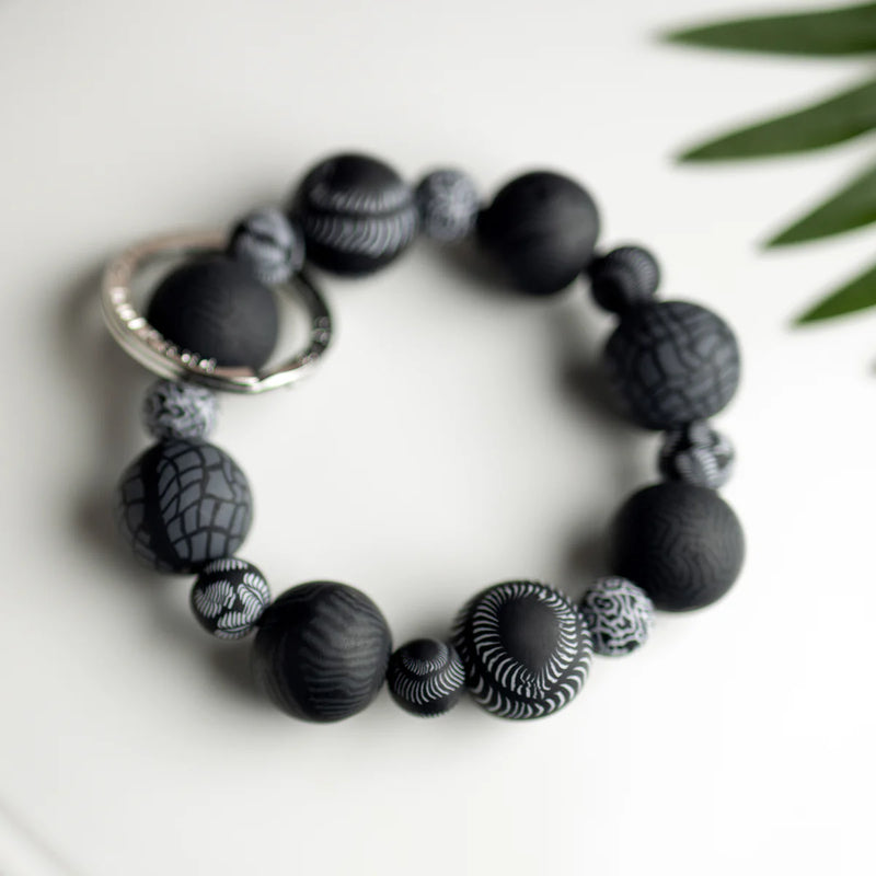 Midnight Palm Keychain with handcrafted black clay beads, elastic cord, and silver key ring featuring JILZARAH logo.