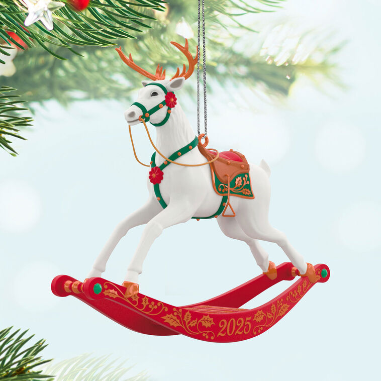 White reindeer Christmas ornament with bronze antlers and hooves, red flower accents, green bridle, on rocking stand

