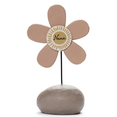 A whimsical resin flower figurine labeled “Nana” in soft neutral tones, designed by Barbara Lloyd.
