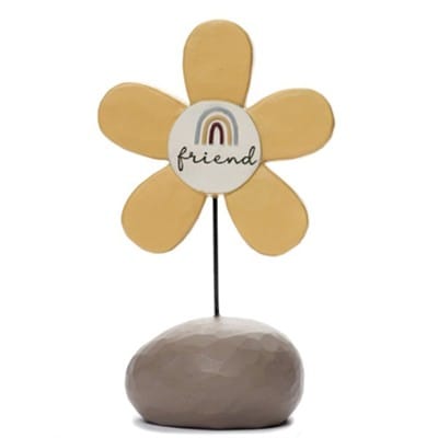 A whimsical resin flower figurine labeled Friend  in soft neutral tones, designed by Barbara Lloyd.
