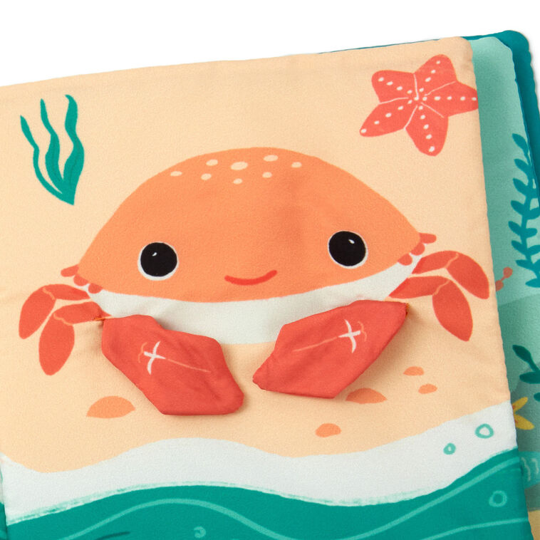 Ocean-themed baby fabric book with sea creature illustrations and tactile features like crinkle paper, squeaker