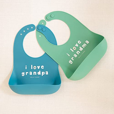 Pink silicone baby bib with “Love Grandma” phrase, features deep food-catching pocket and adjustable neck.

