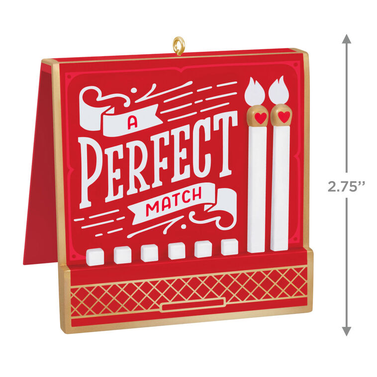 Red and gold matchbook-style ornament with “A Perfect Match” lettering and two heart-accented matchsticks