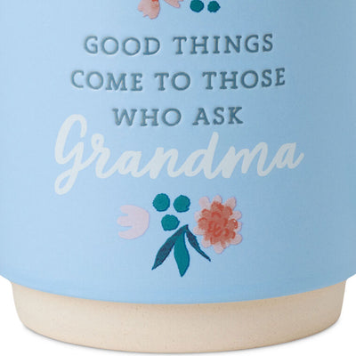 Light blue ceramic mug with “Good things come to those who ask Grandma” text, floral design, and oversized handle.