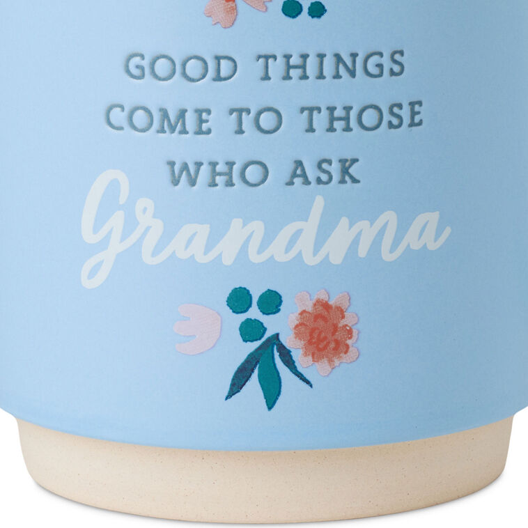 Light blue ceramic mug with “Good things come to those who ask Grandma” text, floral design, and oversized handle.