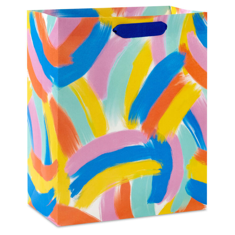 Hallmark medium gift bag with colorful abstract brushstroke rainbows in purple, blue, yellow, and orange on a white background