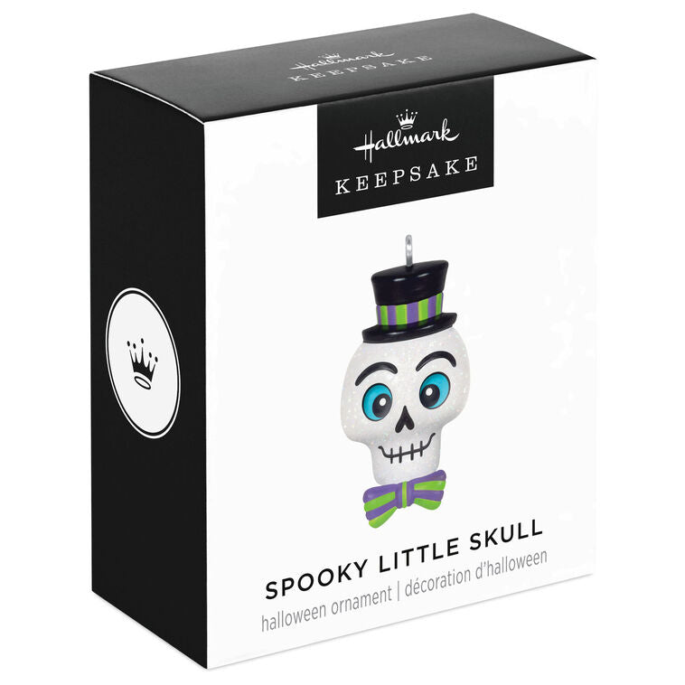 Mini Halloween skull ornament wearing sparkly top hat and bow tie with purple and green accents

