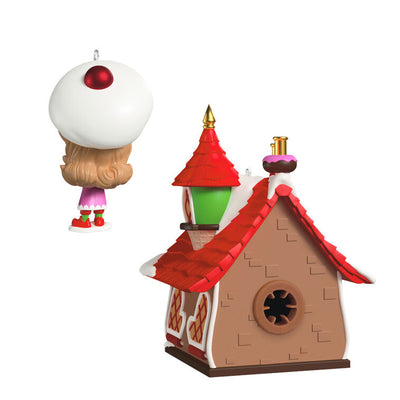 Two-piece ornament set with a festive bakery shaped like a gingerbread house and a smiling elf named Candy holding chocolate cake.