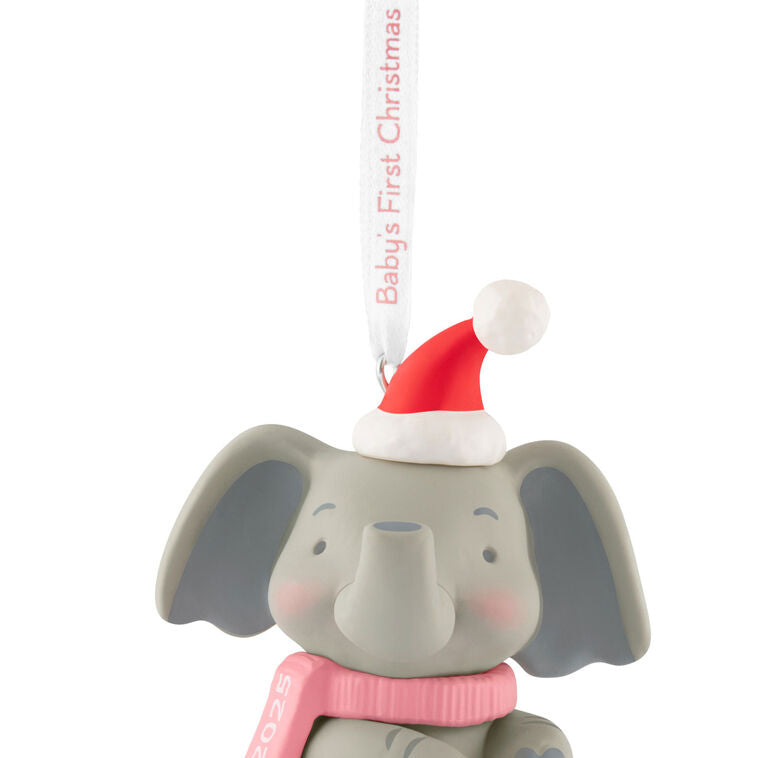 Gray elephant ornament in Santa hat and pink scarf holds a “Baby’s First Christmas 2025” ribbon.