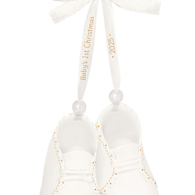 White porcelain baby booties ornament with 14K gold accents and satin ribbon bow, marked for baby’s 1st Christmas 2025.