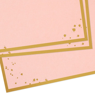 Pink flat note cards with gold foil frame and splatter dot accents, bundled in a kraft wrap.
