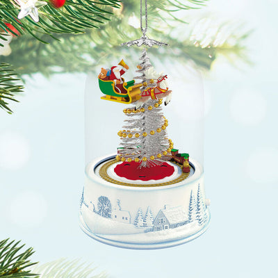 Santa sleigh and toy train under glass dome with lights and motion on snowy village base