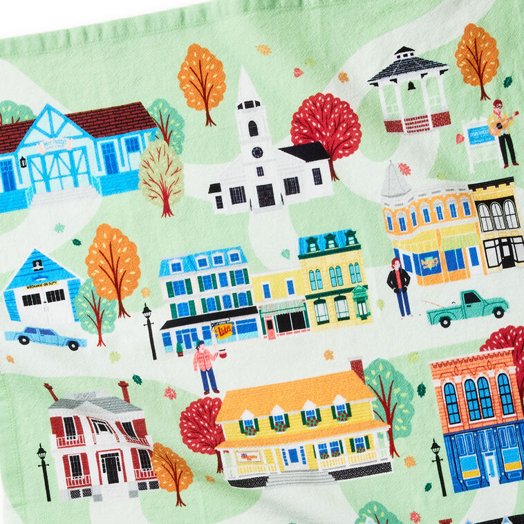 White tea towel printed with a whimsical Stars Hollow map and a central Gilmore Girls quote, includes a loop for hanging.
