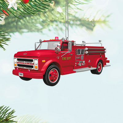 1968 red Chevrolet fire engine Christmas ornament with ladder details, turning wheels, and battery-powered light on front grill.