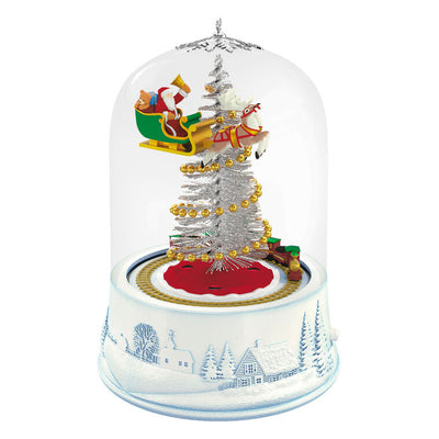 Santa sleigh and toy train under glass dome with lights and motion on snowy village base