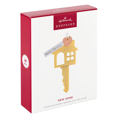 Gold metal key ornament shaped like a house with a pink heart and “New Home” banner charm, for new homeowners.