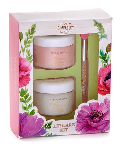 A gift-boxed lip care set with pink jasmine lip balm, lip scrub, and a soft brush labeled “Let Your Dreams Bloom.”

