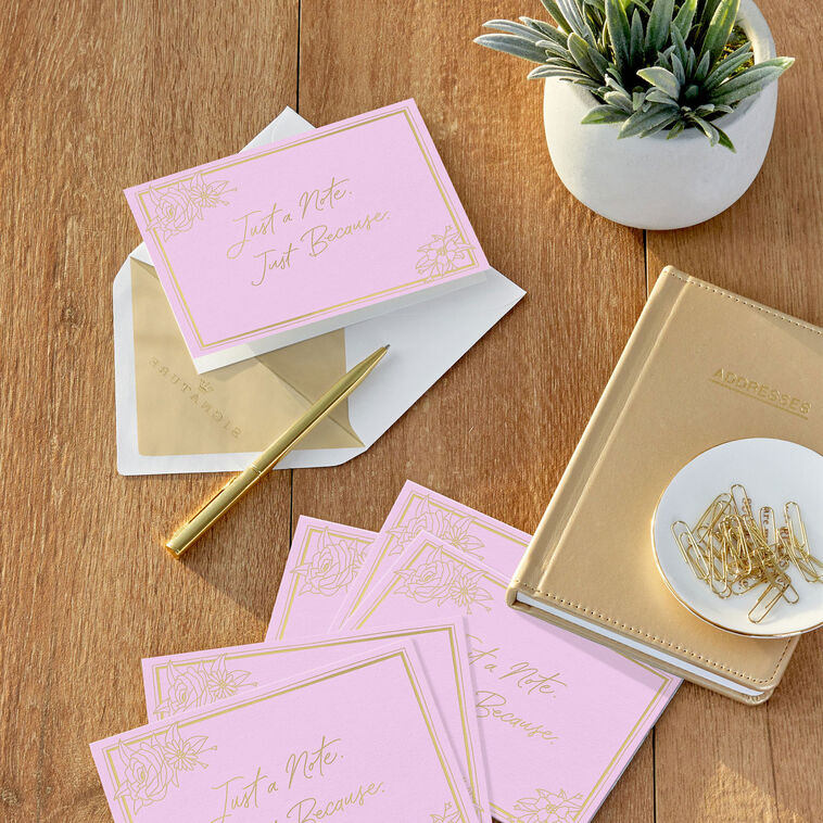 Rose pink blank note cards with gold script lettering and floral corner sketches in kraft box.
