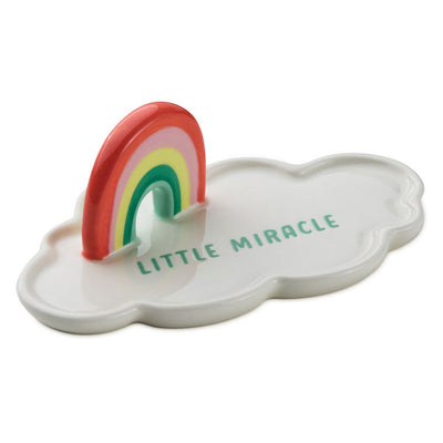 Ceramic cloud-shaped figurine with colorful rainbow arch and “Little Miracle” message in blue lettering.