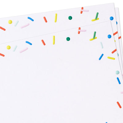 White flat note cards with colorful confetti sprinkle border design, bundled in kraft paper wrap.
